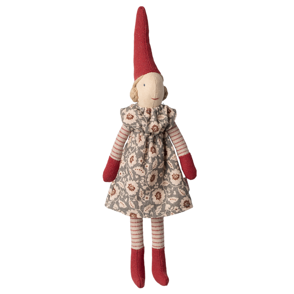 A fabric elf doll with a red pointed hat, red mittens, and socks, wearing a patterned gray dress. The doll has a neutral expression on a white background.