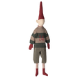 Toy doll in a dark setting, with a tall red hat, striped sweater featuring "24," gray pants, red gloves, striped socks, and red shoes, conveying whimsy.