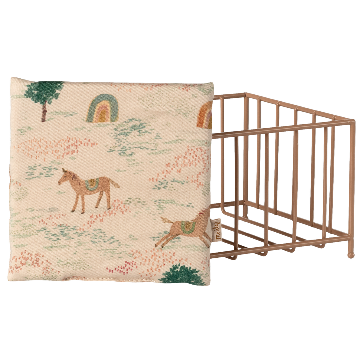 Fabric with a whimsical pattern of horses, trees, and rainbows on a beige background. A pink metal wire grid crate is partially visible on the right.