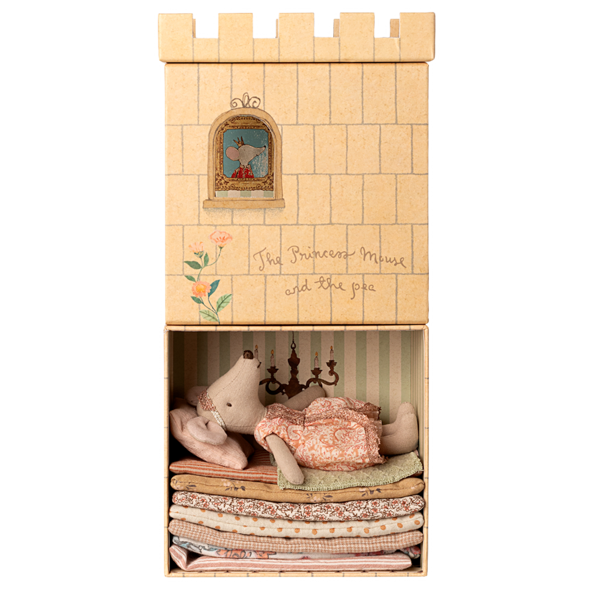 A toy mouse in a pink dress lies atop a stack of colorful fabric mattresses inside a box resembling a castle. A window illustration shows a mouse peeking out. The text reads "The Princess Mouse and the pea."