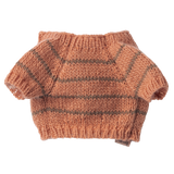 A small peach-colored, hand-knitted sweater with short sleeves and grey horizontal stripes against a white background. Cozy and handmade feel.
