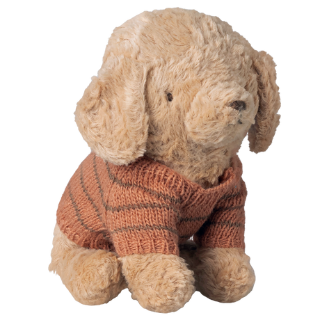 A plush beige puppy wearing a snug, striped brown knit sweater sits against a white background, radiating a cozy and endearing charm.