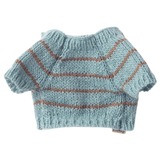 Light blue, hand-knitted doll sweater with brown stripes and short sleeves on a white background. Warm, cozy appearance reflects a handmade charm.
