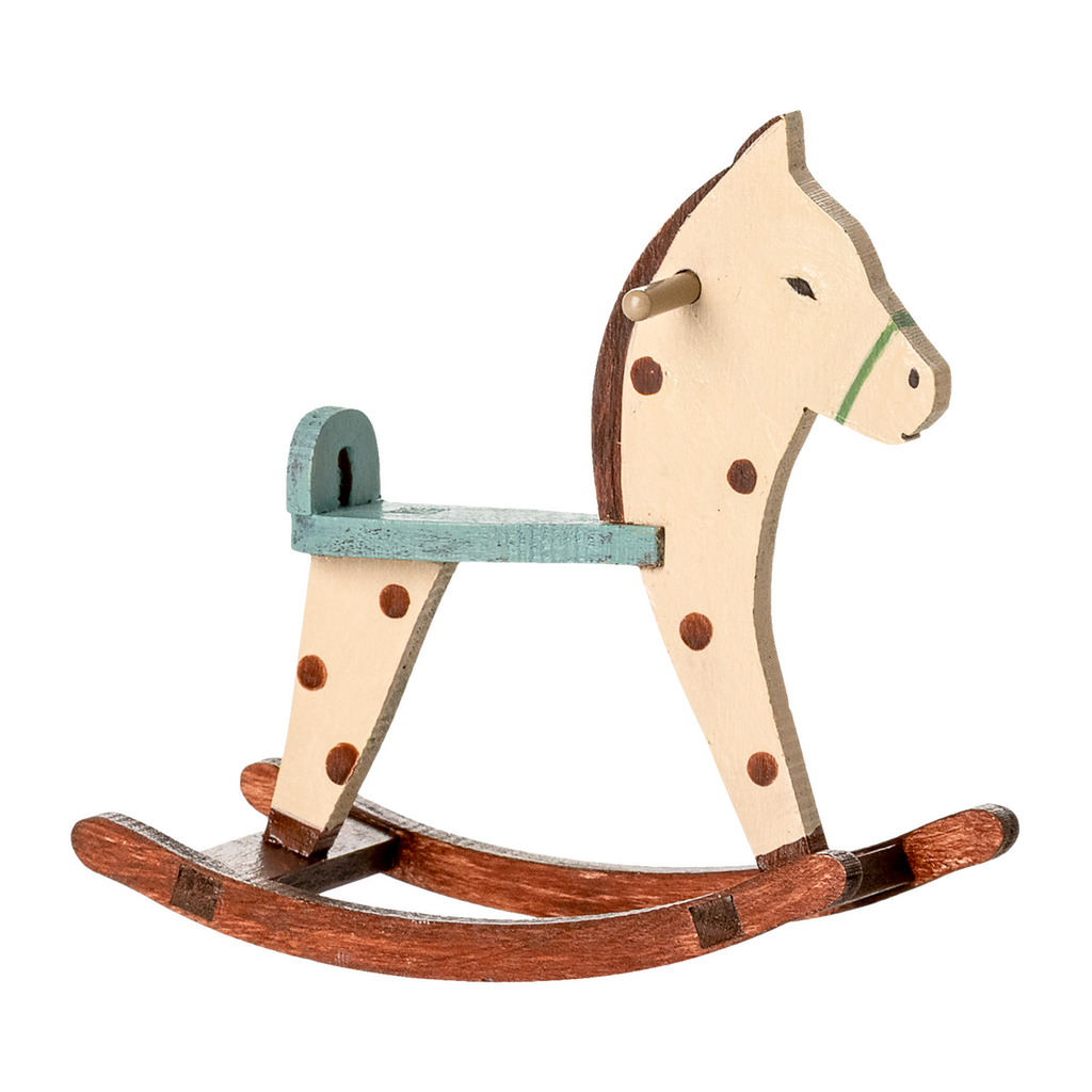 A vintage wooden rocking horse with a cream and brown design, featuring a green saddle and dark spots, sitting on curved wooden rockers.