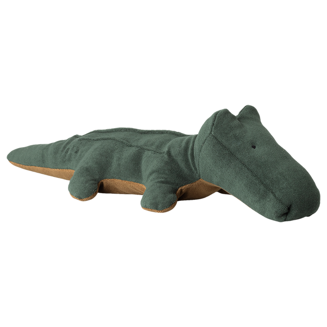 A soft, plush, green crocodile toy with a tan underside lies flat. The toy has a simple, friendly design, creating a playful and calming tone.