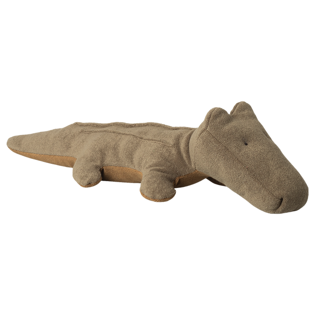A brown, plush alligator toy is shown on a white background. The design is simple and cute, with small eyes and soft texture, conveying a playful tone.