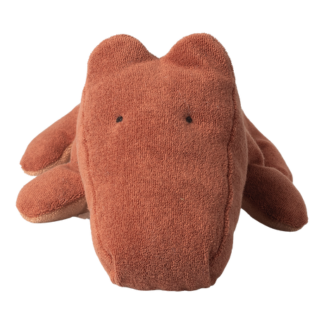 A rust-colored, textured stuffed toy resembling a simplistic animal, likely a bear, on a white background. It has a soft, cuddly appearance.