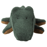 Close-up of a green plush crocodile on a white background, displaying a textured surface and simple, endearing facial features, conveying playfulness.
