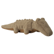 A plush crocodile toy with a beige, textured surface is shown on a white background. Its simple features convey a cozy, playful vibe.