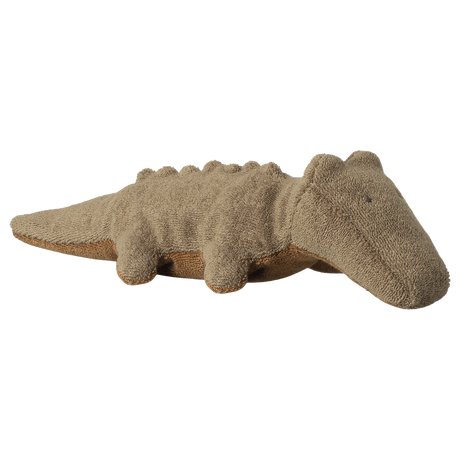 A plush crocodile toy with a beige, textured surface is shown on a white background. Its simple features convey a cozy, playful vibe.