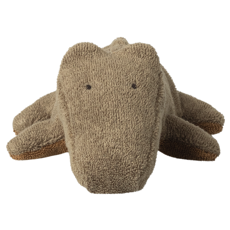 A plush toy crocodile made of textured fabric is centered on a white background. It looks soft and cuddly with a simple, cute expression.