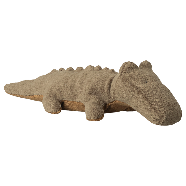 A soft, brown stuffed animal shaped like a crocodile lies against a white background. It has small eyes and a friendly, relaxed appearance.