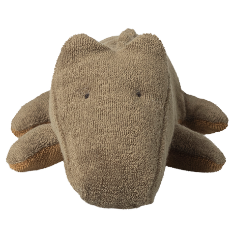 Brown plush toy crocodile with a textured fabric, viewed from the front. It has small black eyes and a cute, minimalist design. The background is white.