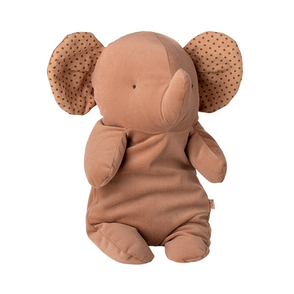 A soft, brown elephant plush toy with polka-dotted ears sits upright. Its simple features and neutral colors convey a cozy, comforting feel.