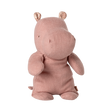 A soft, pink hippo plush toy with small round ears and stitched details sits upright against a plain background, conveying a cute and cuddly vibe.