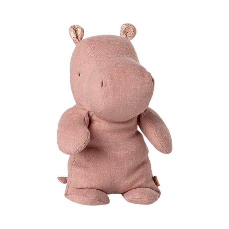 A soft, pink hippo plush toy with small round ears and stitched details sits upright against a plain background, conveying a cute and cuddly vibe.