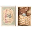 A small brown stuffed mouse rests in an open box, nestled in a yellow-patterned blanket. The box lid features an illustration of an elephant and reads “Baby Jumbo Matches.”