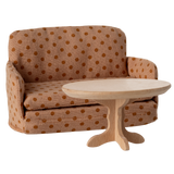 Miniature beige sofa with brown polka dots, featuring plush cushions and compact armrests. The playful design suggests a cozy, dollhouse ambiance.