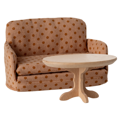 Miniature beige sofa with brown polka dots, featuring plush cushions and compact armrests. The playful design suggests a cozy, dollhouse ambiance.