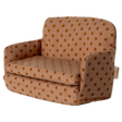 Miniature beige sofa with brown polka dots, featuring plush cushions and compact armrests. The playful design suggests a cozy, dollhouse ambiance.