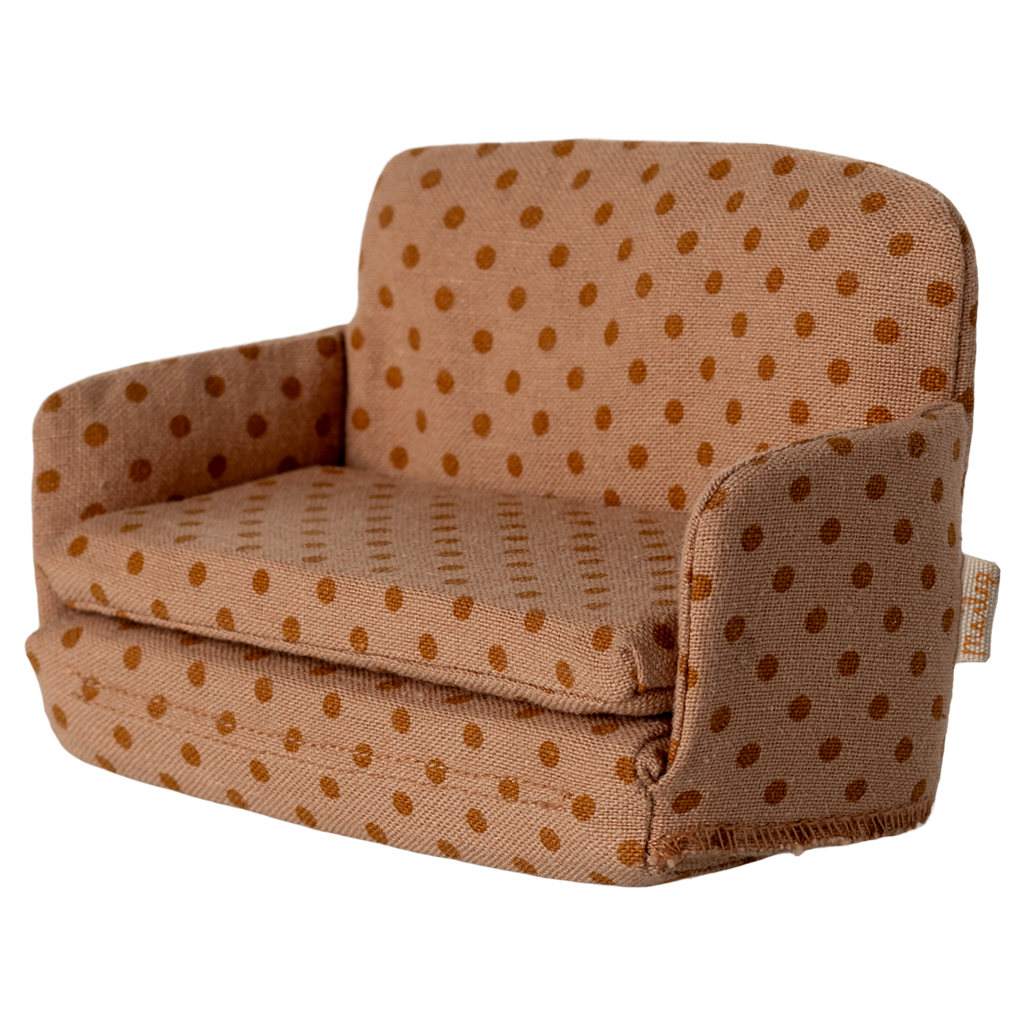 Miniature beige sofa with brown polka dots, featuring plush cushions and compact armrests. The playful design suggests a cozy, dollhouse ambiance.