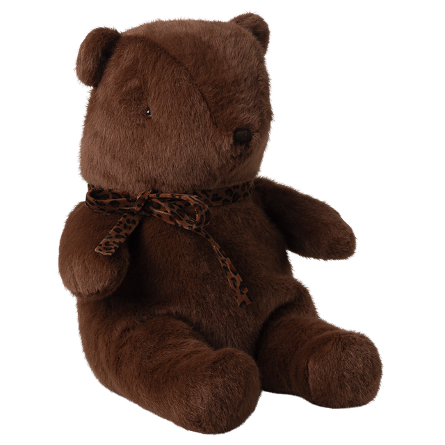 A soft, brown teddy bear with a leopard print scarf sits upright against a white background. The bear exudes a cozy and comforting vibe.
