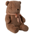 A soft brown teddy bear sits against a white background, adorned with a peach ribbon tied in a bow around its neck, conveying a cozy and cuddly vibe.