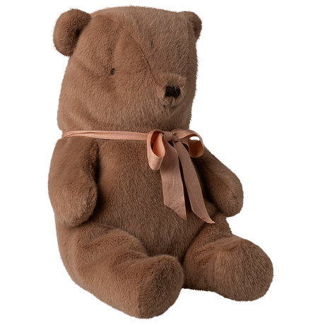 A soft brown teddy bear sits against a white background, adorned with a peach ribbon tied in a bow around its neck, conveying a cozy and cuddly vibe.