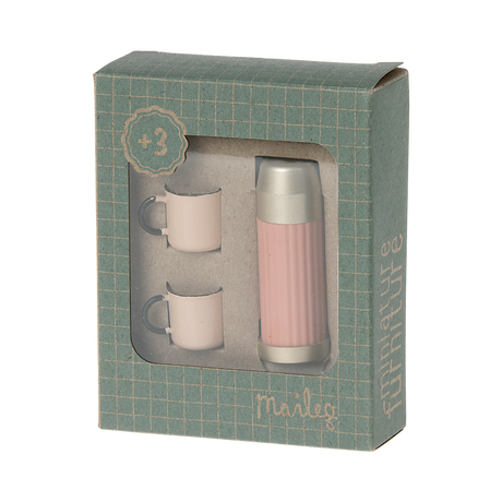 A stylish pink thermos with a gold lid and two matching pastel cups in white background.