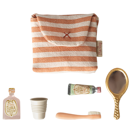 A small striped pouch and miniature items: two perfume bottles, a collapsible cup, a toothbrush, and a vintage-style hand mirror, arranged on a white background.
