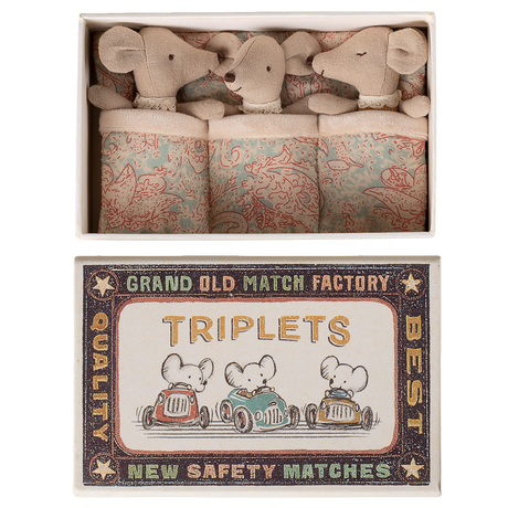 A matchbox labeled "Triplets" contains three plush mice cuddled in patterned blankets, exuding a cozy and whimsical tone.