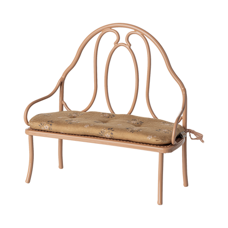 Vintage-style miniature wrought iron bench with a light brown, floral-patterned cushion. The elegant curves of the metal frame add a classic charm.