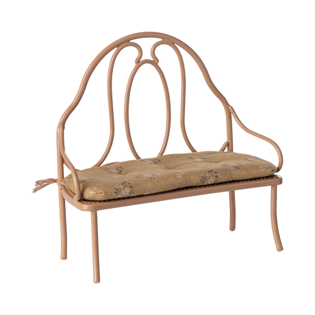 Vintage-style miniature wrought iron bench with a light brown, floral-patterned cushion. The elegant curves of the metal frame add a classic charm.