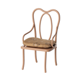 Elegant miniature antique chair with a beige floral-patterned cushion. The chair has curved metal legs and intricate, looping back design, conveying vintage charm.
