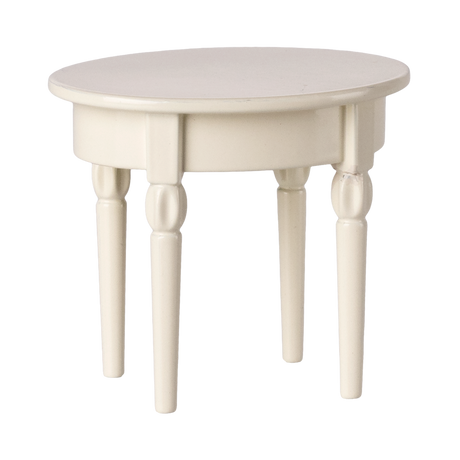 A miniature, round, cream-colored table with four turned wooden legs. The table has a smooth surface and a classic, minimalist design.