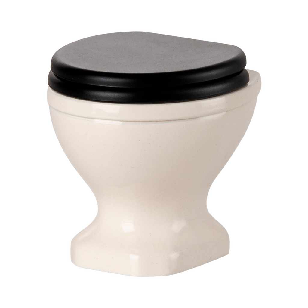 A miniature, white ceramic toilet with a black seat and lid open, set against a plain black background, conveying a quirky and playful tone.