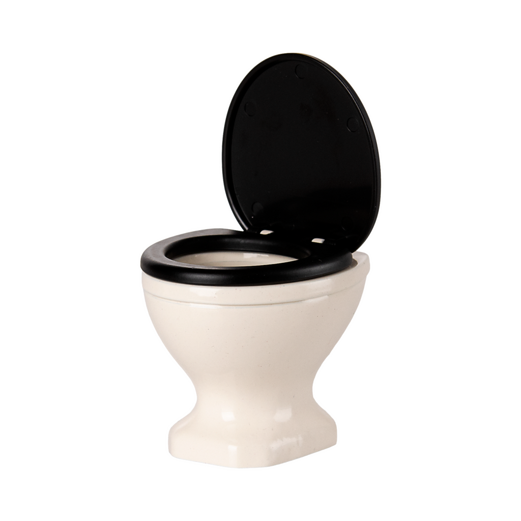 A miniature, white ceramic toilet with a black seat and lid open, set against a plain black background, conveying a quirky and playful tone.