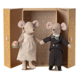 Two stuffed mice dressed as a bride and groom stand inside an ornate, open box. The bride holds a bouquet, and the groom wears a bow tie.