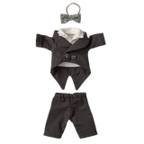 Black doll tuxedo set against a white background, featuring a small bow tie, a double-breasted jacket with white lining, and matching pants.