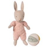 Maileg micro rabbit wearing a pink knitted suit standing next to a small fabric ball on a white background.
