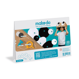 Back packaging for a Makedo craft kit showing eye props, tools, and a child wearing a cardboard box mask.