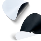 Close-up of black and white curved paper cutouts with grommet center holes against a white background.