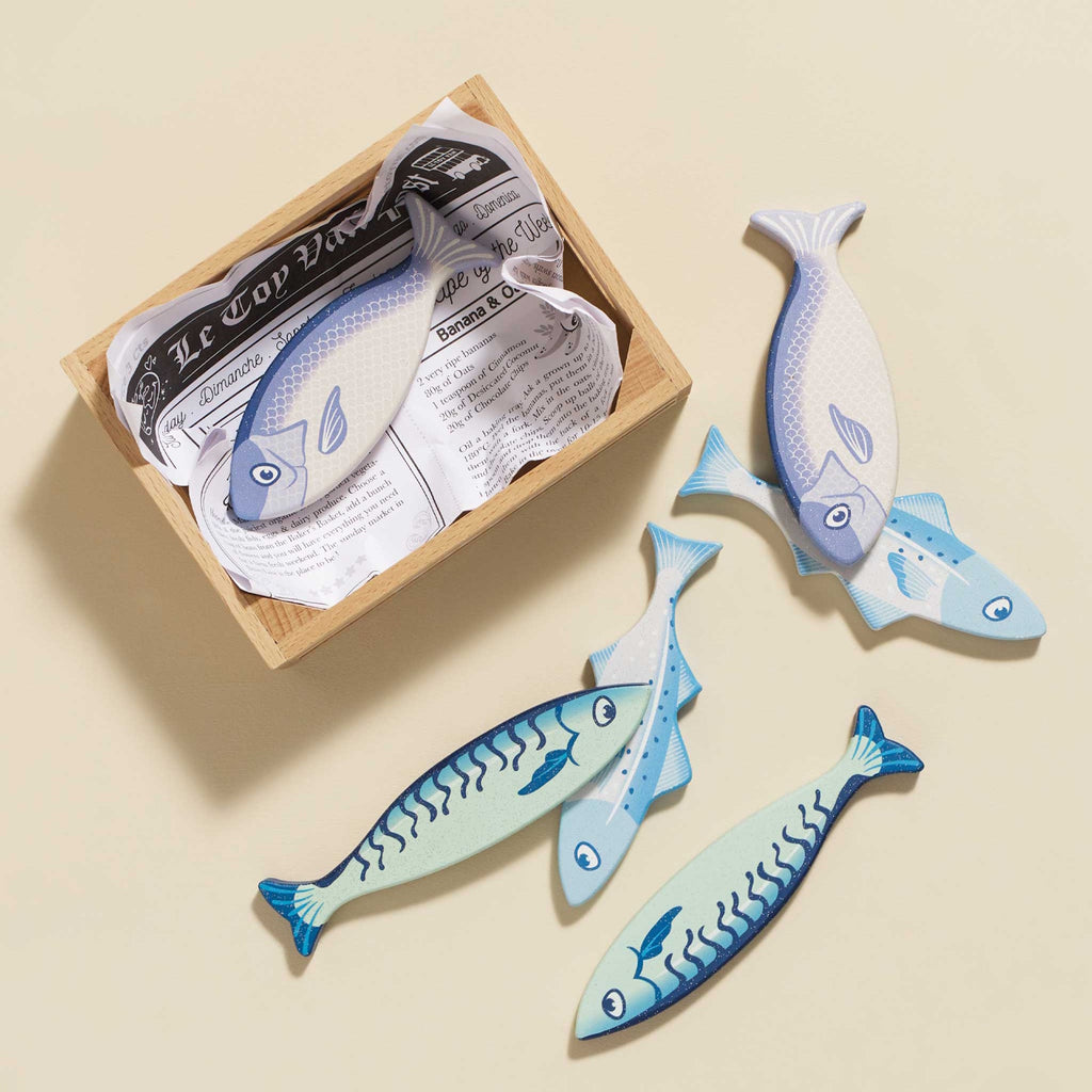 Wooden box with playful toy fish in blue tones. Fish feature simple smiling faces, conveying a cheerful and whimsical tone.