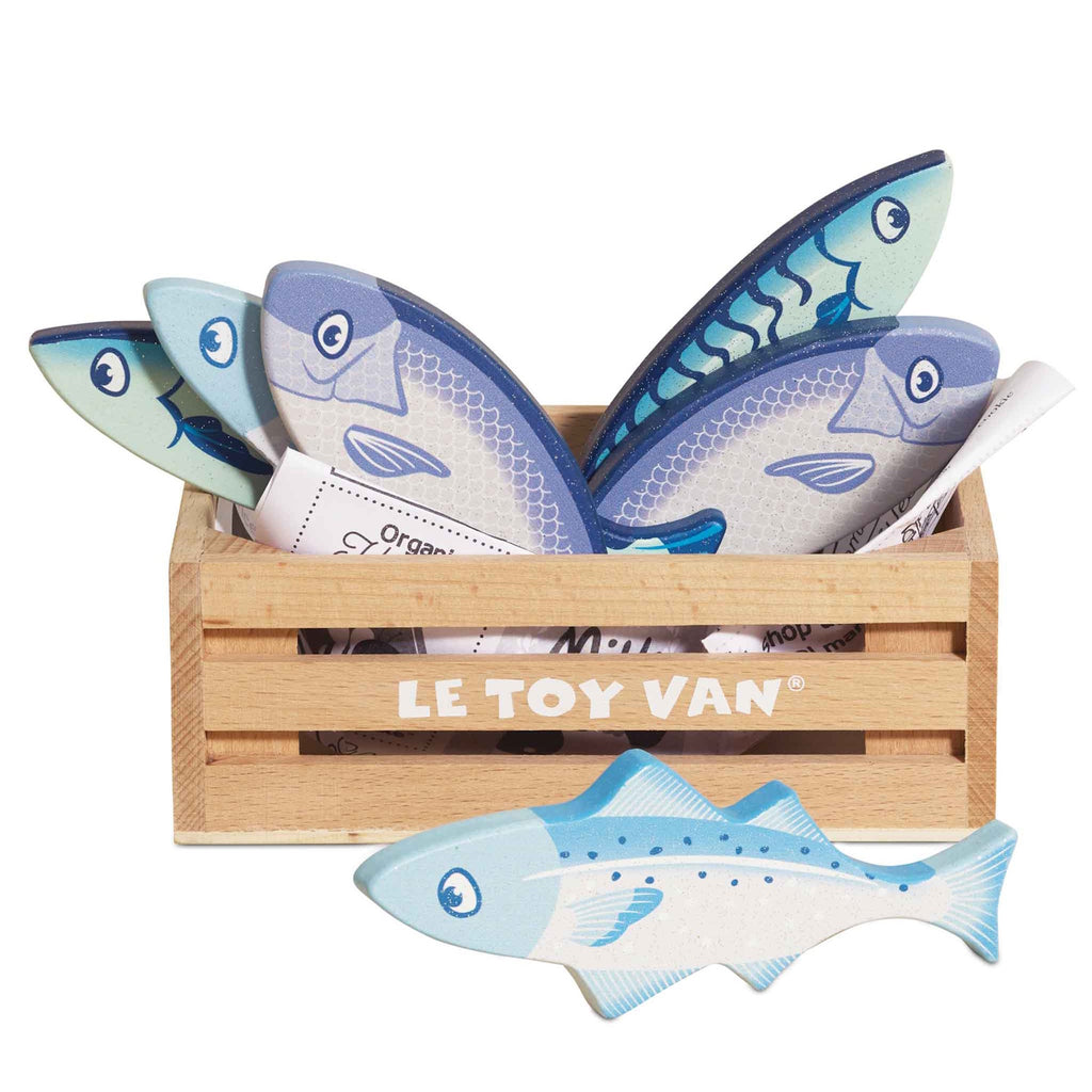 Wooden box with playful toy fish in blue tones, labeled "LE TOY VAN." Fish feature simple smiling faces, conveying a cheerful and whimsical tone.