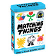 Matching Things: A Snap Card Game tin box featuring colorful, quirky illustrated characters.