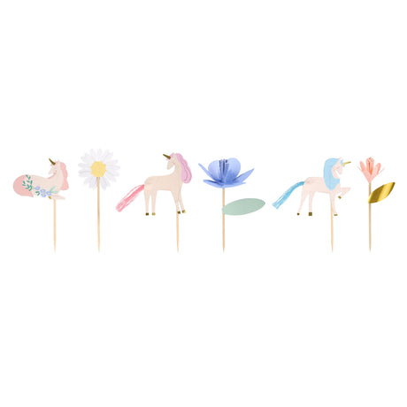 Line-up of six decorative cupcake toppers including unicorns, flowers, and a daisy on wooden picks.