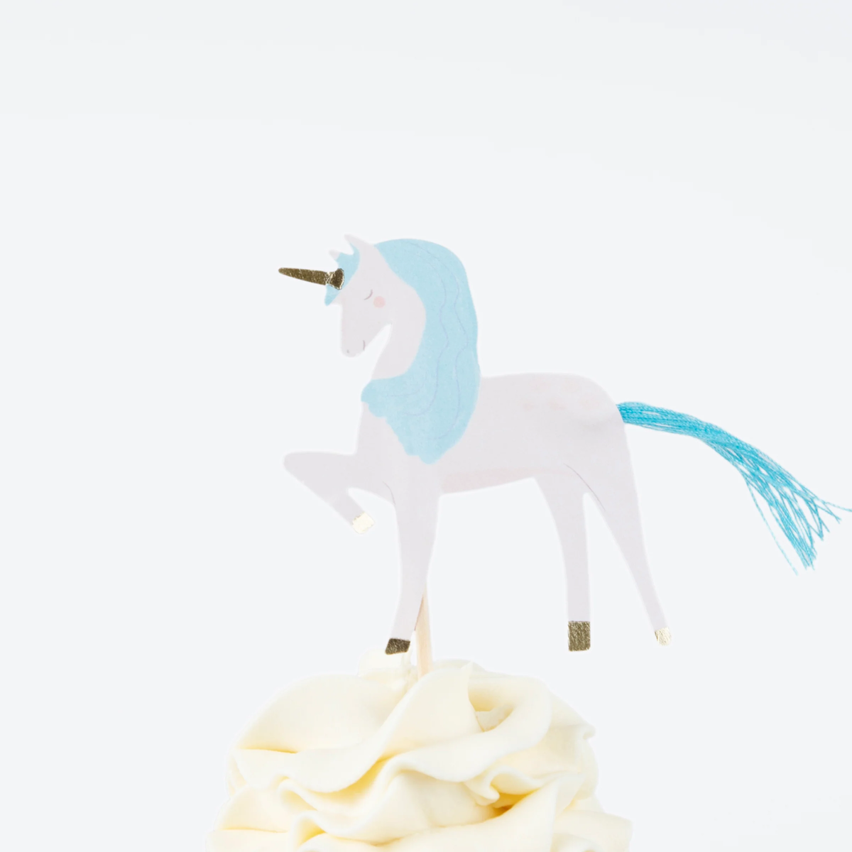 Blue-maned unicorn topper with gold horn and hooves standing on swirled white cupcake frosting.