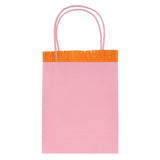 Light pink Meri Meri party gift bag featuring orange crepe paper fringe and pink twine handles on a white background.