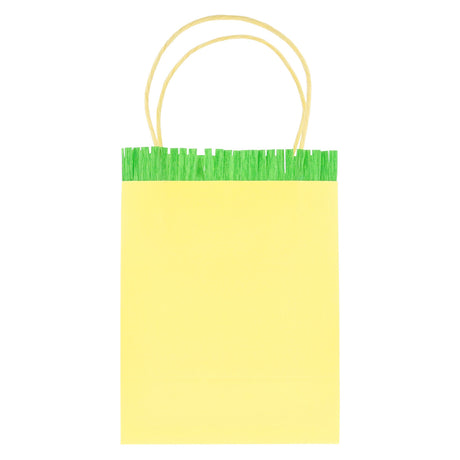 Yellow paper party gift bag with green fringed crepe paper trim and twisted paper handles.