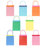 Set of 8 colorful Meri Meri party bags with fringe trim and matching twine handles in various bright shades.